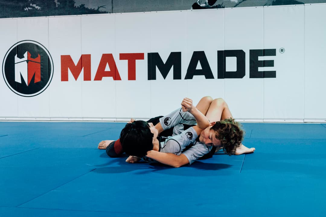 Brazilian Jiu Jitsu Teenagers at Kenny Kim BJJ in Marietta GA rolling on the mats practicing techniques