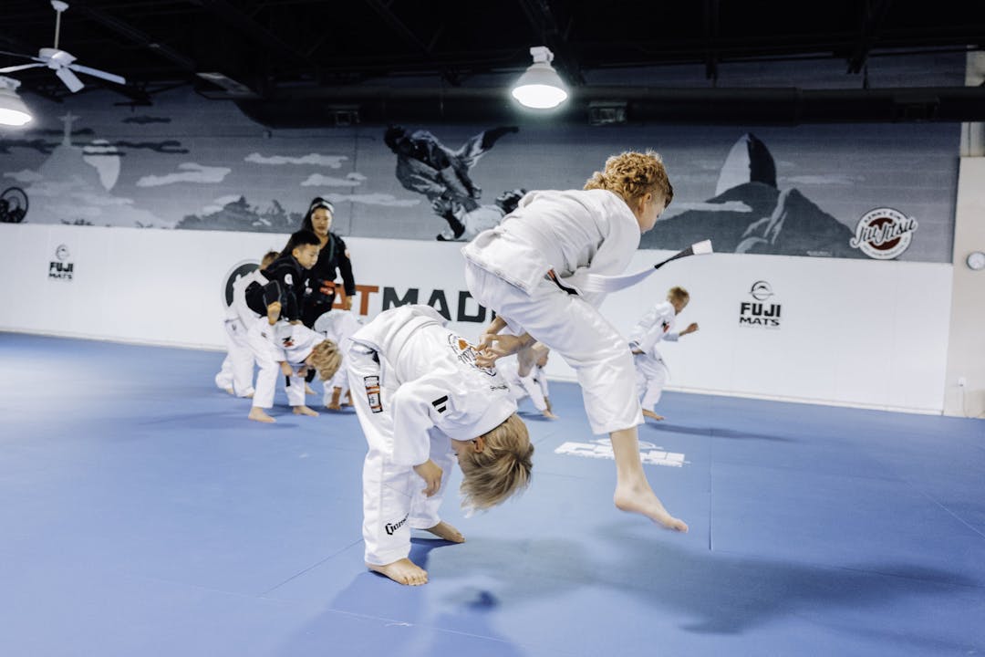 Brazilian Jiu Jitsu Kids at Kenny Kim BJJ in Marietta GA jumping over one another for a warm up in class