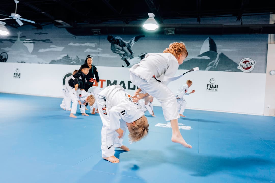 Brazilian Jiu Jitsu Kids at Kenny Kim BJJ in Marietta GA jumping over one another for a warm up in class