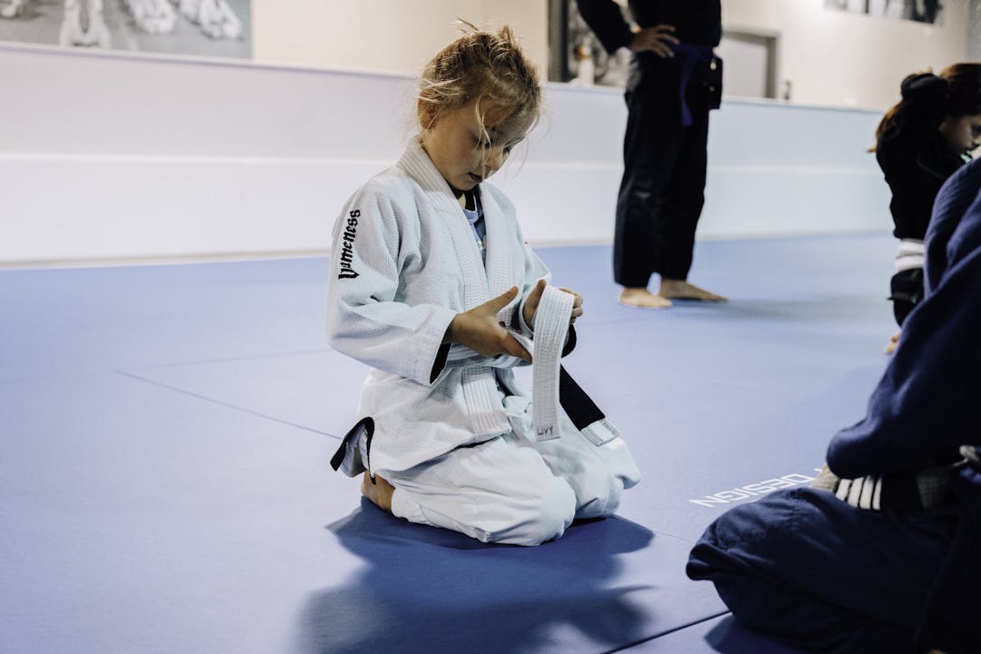 Brazilian Jiu Jitsu Girl at Kenny Kim BJJ in Marietta GA tying her belt before class