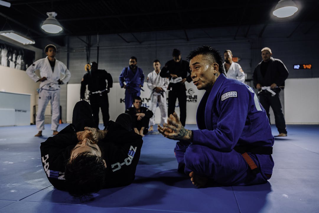 Brazilian Jiu Jitsu Students at Kenny Kim BJJ in Marietta GA being taught by Kenny Kim on the mats wearing a blue gi