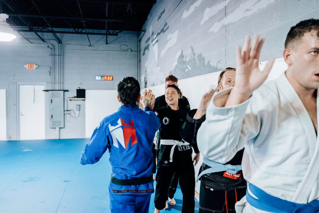 Adult Brazilian Jiu Jitsu Students at Kenny Kim BJJ in Marietta GA high-fiving Kenny Kim after an great training session