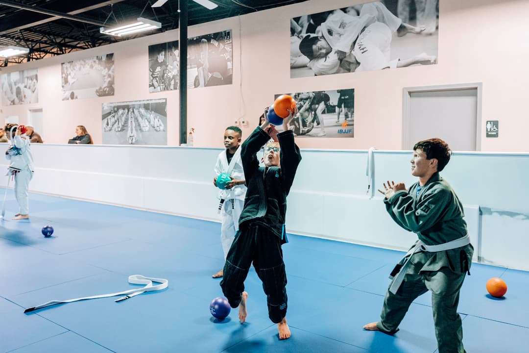 Brazilian Jiu Jitsu Kids at Kenny Kim BJJ in Marietta GA catching a dodgeball while warming up for class